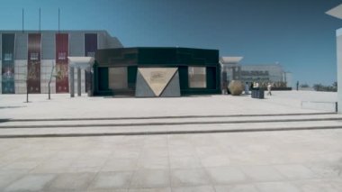 Mısır Medeniyeti Ulusal Müzesi (NMEC) Kahire 'de, Mısır' ın dış kesiminde gün ışığında yakınlaştırma ve tarama yaparak müzenin ana girişini ziyaretçilerin yürüdüğü göstermektedir.