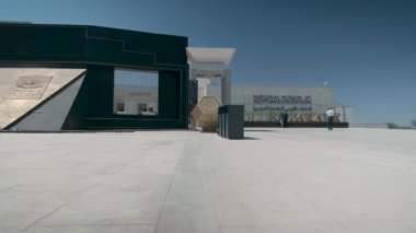 Mısır Medeniyeti Ulusal Müzesi (NMEC) Kahire 'de, Mısır' ın dış kesiminde gün ışığında yakınlaştırma ve tarama yaparak müzenin ana girişini ziyaretçilerin yürüdüğü göstermektedir.