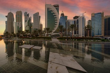 Batı körfezindeki Doha silueti öğleden sonra Sheraton Parkı 'ndan çekildi. Ön planda yapay göl, arka planda bulutlar.