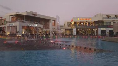 Kahire, Mısır - 28 Aralık 2024: Kahire festivali alışveriş merkezi yemek salonu fıskiyeleri, restoranlar, kahve dükkanları, arka planda insanlar ve bulutlar