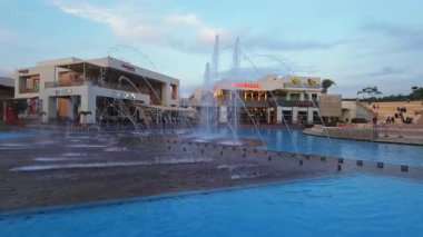 Kahire, Mısır - 28 Aralık 2024: Kahire festivali alışveriş merkezi yemek salonu fıskiyeleri, restoranlar, kahve dükkanları, arka planda insanlar ve bulutlar