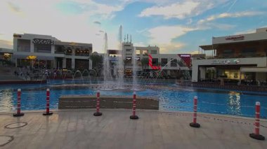 Kahire, Mısır - 28 Aralık 2024: Kahire festivali alışveriş merkezi yemek salonu fıskiyeleri, restoranlar, kahve dükkanları, arka planda insanlar ve bulutlar