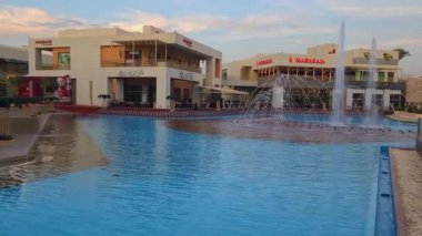 Kahire, Mısır - 28 Aralık 2024: Kahire festivali alışveriş merkezi yemek salonu fıskiyeleri, restoranlar, kahve dükkanları, arka planda insanlar ve bulutlar