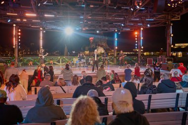 Orlando, Florida, ABD-9 Aralık 2025: Disney Springs, Orlando yakınlarındaki Lake Buena Vista 'da Walt Disney World Resort' ta bulunan bir açık hava alışveriş, yemek ve eğlence tesisidir. Sahne sahnesini canlı performansla gösteren gece çekimi