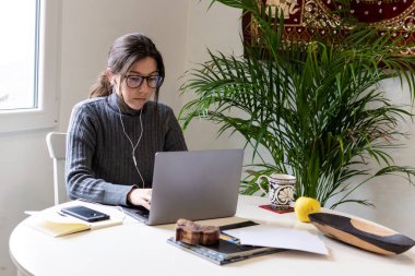 Karantina sırasında evde bilgisayarında çalışan genç bir kadın tele-sekreter.