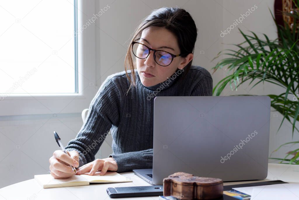 Young woman freelancer tele working on her computer at home during quarantine