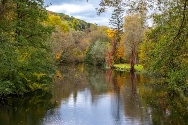 Almanya 'daki River Glan nehri sonbahar renklerinde ağaçlarla çevrilidir