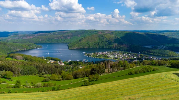 Almanya 'nın Eifel bölgesindeki Rursee' nin ön planda tarım arazisi ve Woffelsbach bölgesi hava manzarası