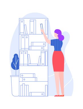 Kadın ofis çalışanı dizinleri rafta düzenler