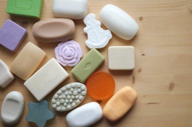 Spa ve sağlık konsepti. Doğal sabun, banyo sabunu, deniz tuzu, sabun ve banyo köpüğü ahşap arka planda, üst manzara.