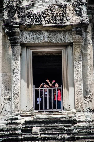 The traveller at window of the tower of Angkor wat, Cambodia- Au — Stock Photo, Image