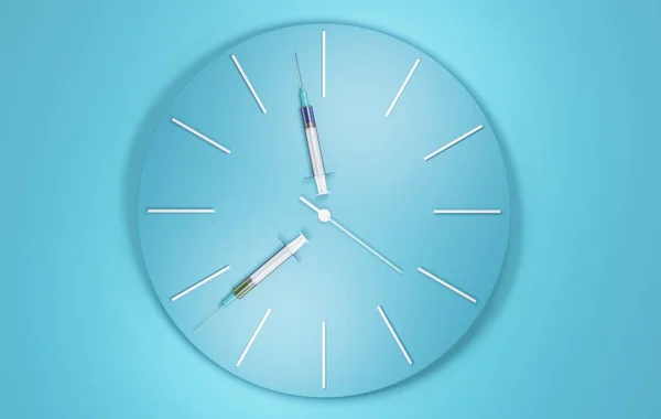 Часы Шприцами Руках Голубой Стене Концепция Ожидания Вакцины Иллюстрация Стоковое Фото