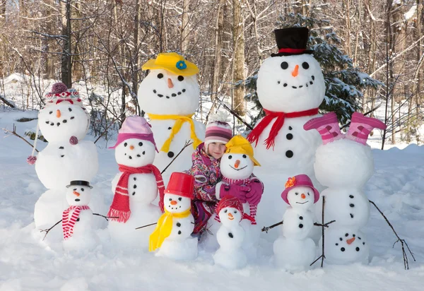 Menina com bonecos de neve — Fotografia de Stock