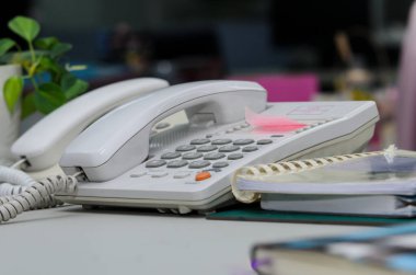 Masanın üzerinde defter olan bir telefon.