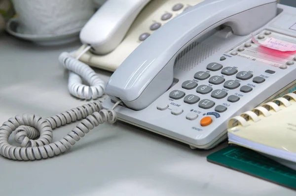 Masasında defter olan bir telefon.