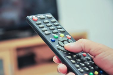 Eller TV kumandasına basıyor.