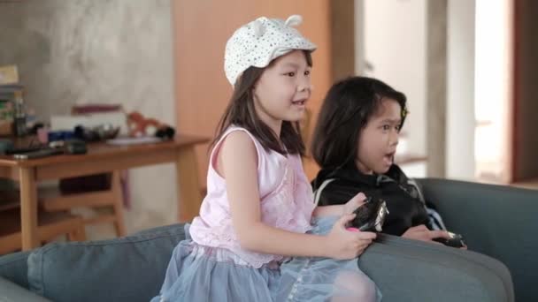 Dos Chicas Asiáticas Sentadas Sillón Gris Disfrutando Videojuegos Sala Estar — Vídeo de stock