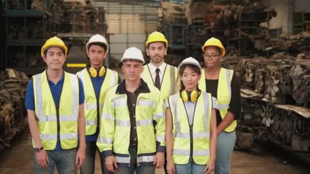 制服やヘルメットのエンジニアの様々な民族が立っている 腕を横断し 喜んで笑顔 すべての同僚は 機械スペアパーツ倉庫工場での専門的なチームワークです — ストック動画