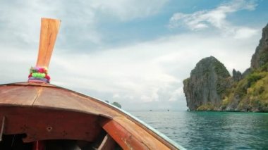 Geleneksel Tayland ahşap pruva teknesinden görüntü: Andaman Denizi 'nde açık havada hızlı ulaşım, güzel doğal manzara, dağlar ve mavi gökyüzü, yazın fırtınalı olabilecek bulutlar.