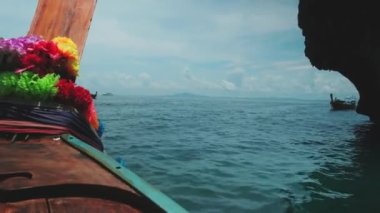 Geleneksel Tayland ahşap pruva teknesinden görüntü: Andaman Denizi 'nde açık havada hızlı ulaşım, güzel doğal manzara, dağlar ve mavi gökyüzü, yazın fırtınalı olabilecek bulutlar.