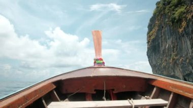 Geleneksel Tayland ahşap pruva teknesinden görüntü: Andaman Denizi 'nde açık havada hızlı ulaşım, güzel doğa manzarası, dağlar ve mavi gökyüzü, yazları bulutlu, fırtınalı olabilir. Anahtar kelime: manzara, dağ ve