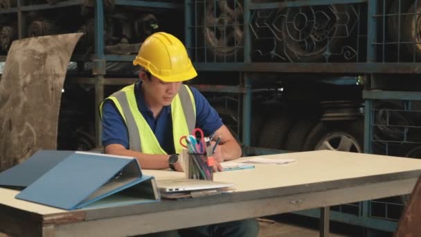 Ein Junger Asiatischer Arbeiter Mit Gelbem Helm Sitzt Einem Schreibtisch — Stockvideo