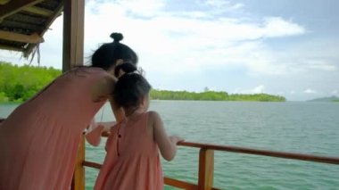 Asyalı turistler anne ve kızı aynı renkte giyinmişler, tahta salda takılıyorlar. Mangrov ormanlarının ekosistemi, yemyeşil ağaçlar, nehirler ve kanallar, Tayland 'da doğal tropikal çevre.