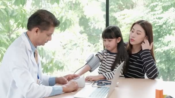 母親は病気の娘を小児科のアジア系男性医師の診察予約に連れて行きます 病気を治療し 家族の健康を相談する — ストック動画