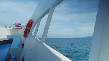 Tatilde Tayland 'daki körfezlerden gelen turistleri feribotun pruvasından görmek güzel manzara, mavi deniz, güneşli bir günde bulutlu gökyüzü. Teknenin güvertesinde bir can simidi var..