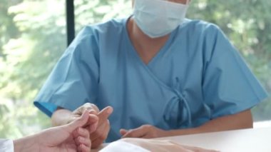Kadın doktor, erkek bir Asyalı hastanın kanını diyabet ve sağlık testleri için insülin ölçer cihazıyla hastane kliniğinde muayene ediyor. Glikoz kontrolü ve tıbbi tedavi için kullanılan laboratuvar analizi.
