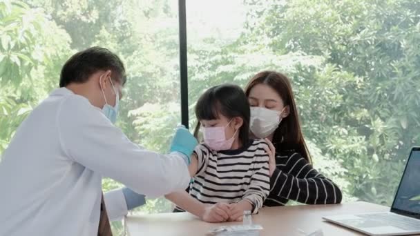 Manlig Läkare Med Ansiktsmask Vaccinerar Asiatisk Flicka För Att Förhindra — Stockvideo