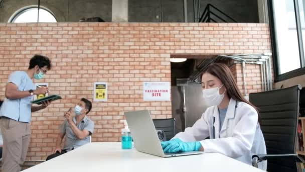 护士检查接种了疫苗的队列 保护验尸官 Covid 的健康护理活动 病人坐在那里 与他人保持距离 并戴上口罩 以预防疾病感染 — 图库视频影像