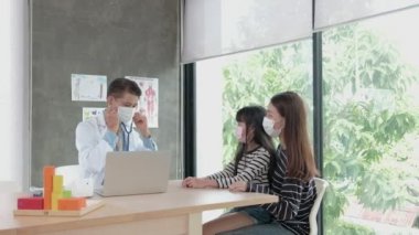 Yüz maskesi takan bir anne hasta kızını çocuk kliniğinin pediatri bölümündeki Asyalı bir erkek doktorla muayeneye getirir. Hastalıkları tedavi etmek ve aile sağlığı konusunda danışmanlık yapmak için..
