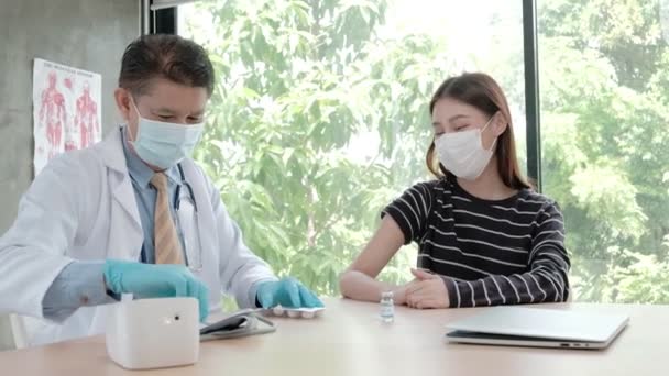 为亚洲妇女接种口罩的男医生 在医院诊所保护头孢病毒 Covid 注射是一种疾病的治疗 用健康的药物预防疾病的感染 — 图库视频影像