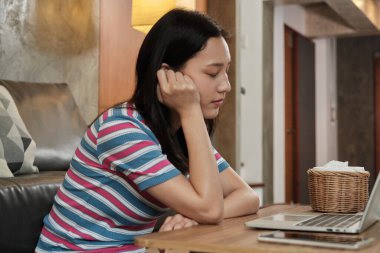 Serbest Asyalı bir kadın internette bilgisayar kullanmaktan, e-ticaret sohbetinden ve internetten yeni normal bir yaşam tarzında çalışmayı öğrenmekten dolayı uyukluyor..