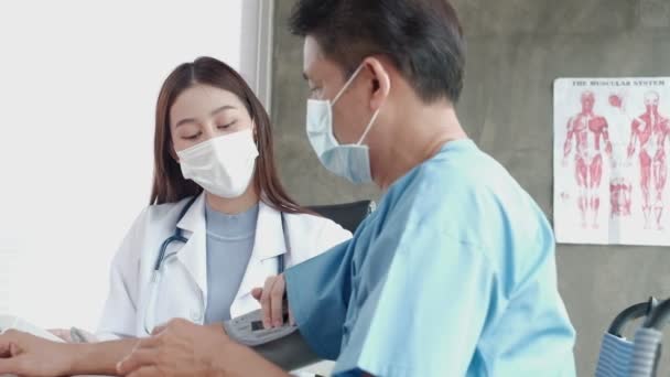 Asian Female Doctor Face Mask Checks Health Elderly Handicapped Man — Stock Video