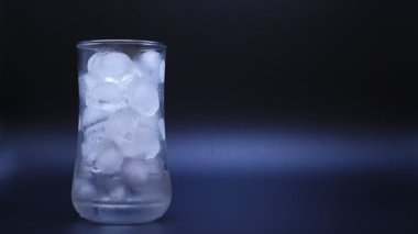 Yakın çekim hızlandırılmış videoda sıcaklık artarken fotokopi uzayının siyah zemininde buzun eridiğini görüyoruz. Dünya iklim değişikliği ve sera etkisinden kaynaklanan küresel ısınma hakkında.