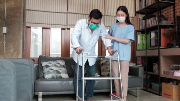 아시아 치료사가 보행기를 장애인 남성을 집에서 훈련시키고 재활시키고 격려와 관리를 — 비디오