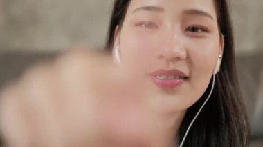 Asyalı bir kadın internet konferansı için cep telefonu uygulamasından kablosuz teknolojiyle kamerayla sohbet ediyor. Toplantıda ön görünümde bir konuşmaya başlamak için ekrana dokunmak için parmak kullanmak.