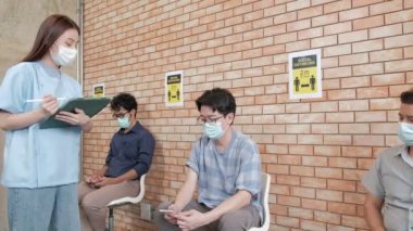 Hemşire, aşılanmış insan kuyruğunu kontrol eder, Coronavirus 'u (COVID-19) sağlık kampanyası için korur. Maske takan hastalar hastalıktan korunmak için oturup beklerler.. 