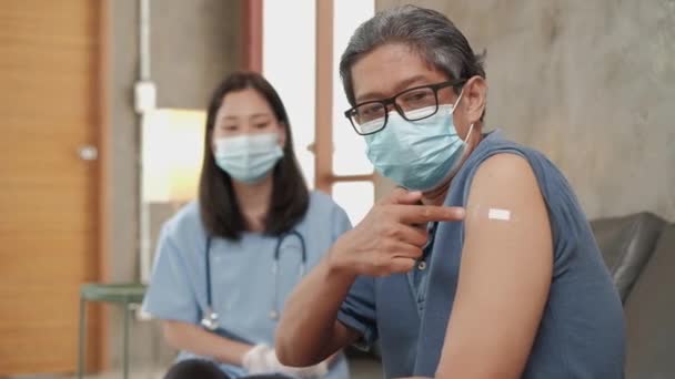 予防接種後 顔マスクやアジア女性医師の親指で病気の高齢男性患者 インフルエンザ 健康を予防する老人ホーム医療サービスです — ストック動画