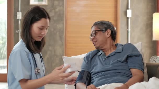 Kobieta Lekarz Sprawdzający Zdrowie Azjatyckich Starszych Pacjentów Płci Męskiej Domu — Wideo stockowe