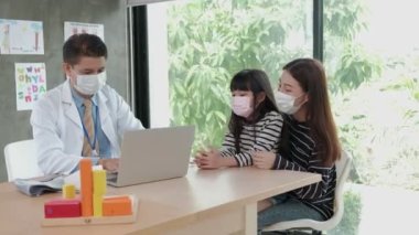 Yüz maskesi takan bir anne hasta kızını çocuk kliniğinin pediatri bölümündeki Asyalı bir erkek doktorla muayeneye getirir. Hastalıkları tedavi etmek ve aile sağlığı konusunda danışmanlık yapmak için..