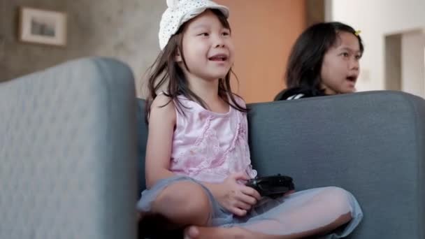 Две Азиатки Повседневной Одежде Играют Забавные Видеоигры Сером Кресле Гостиной — стоковое видео