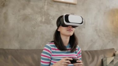 Sanal gerçeklik simülasyonu izleyen, VR gözlüklü Asyalı bir kadın. Etkileşimli eğlence teknolojisi aleti. İnsanlar gelecekteki siber uzay yeniliğine giriyorlar. 
