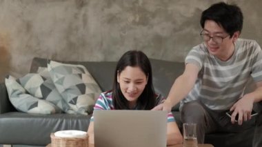 İnternette iş için dizüstü bilgisayar kullanan Asyalı bir kadın, e-ticaret sohbeti, ve internet eğitimi, arka koltukta oturan kardeşi. İki kardeş de COVID-19 'dan karantinaya alındıkları için evde çalışıyor..