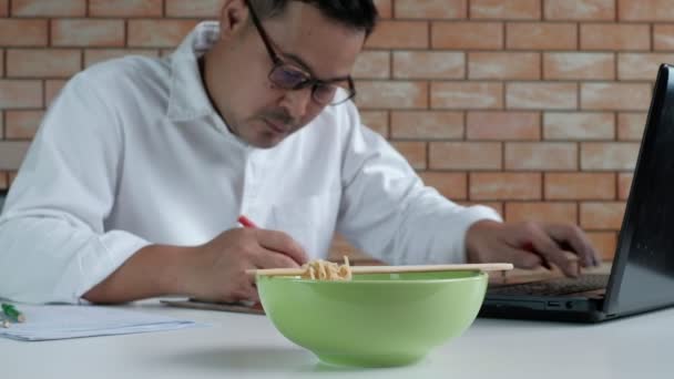 Trabajador Masculino Tailandés Ocupado Trabajando Con Ordenador Portátil Utilice Palillos — Vídeos de Stock