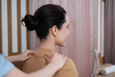 İspanyol kadın hasta omuz masajı yapıyor, kas germe, ağrı kesici için fizik tedavi uzmanı tarafından tedavi görüyor, kaplıca kliniğinde pasif tıbbi tedavi ve sağlık hizmetleri..