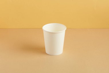 Kağıt bardak zemin rengi arkaplanına konacak. Orman rengi uyuştu. Kahverengi arka planda tek kullanımlık bardak. Boşluğu kopyala, metin için yer