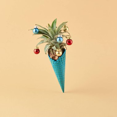 Creative minimal xmas concept. Ice cream cone with pineapple and baubles on set sail champagne background. Tropical minimal christmas clipart